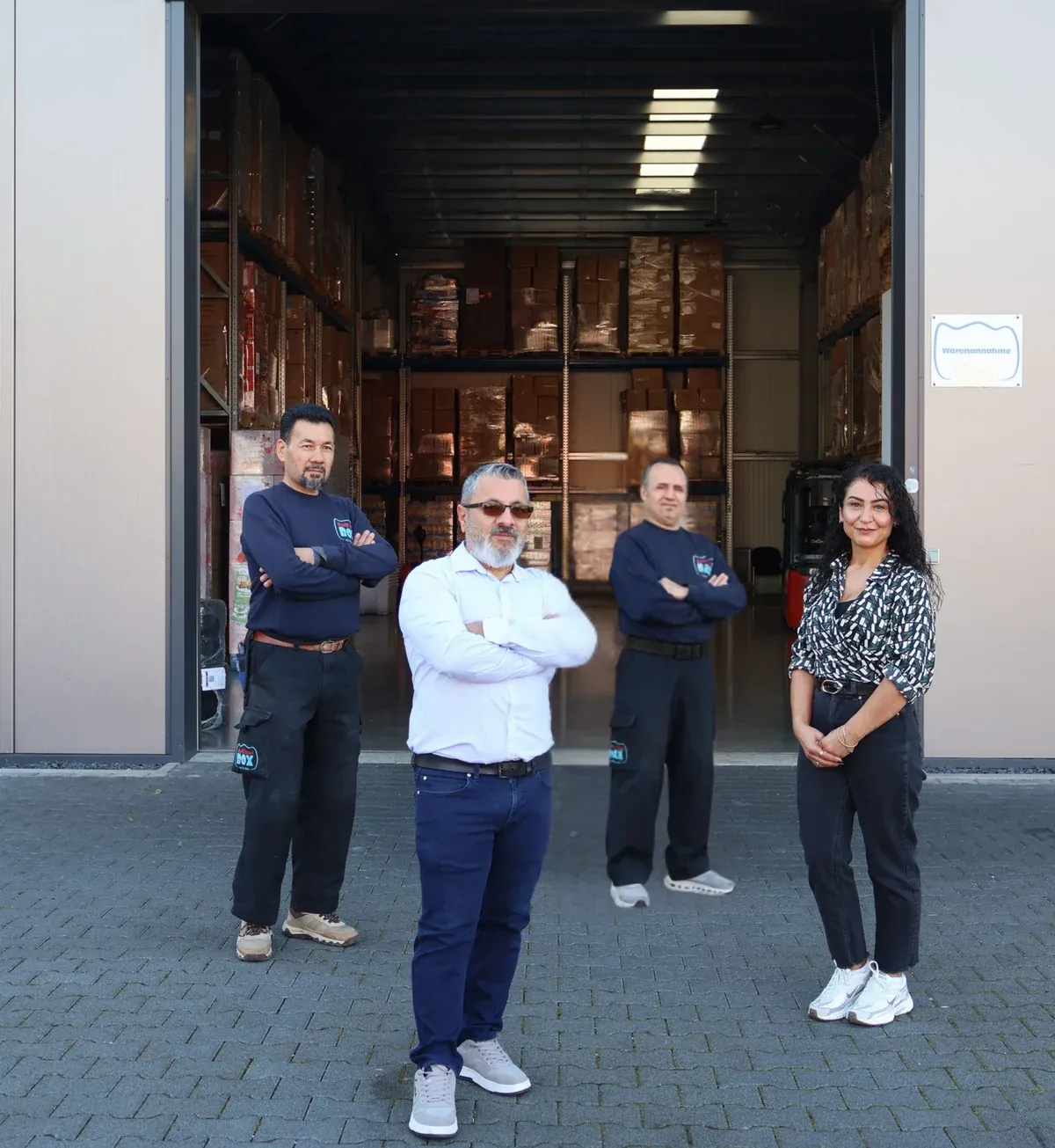 Geschäftsführer Ugur Doganay, seine Ehefrau und das Lager-Team vor dem geöffneten Logistiktor der Happy Kids Box GmbH eat&play in Bad Hönningen